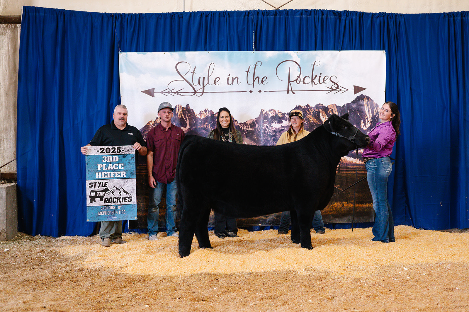 Black heifer and her family with the 3rd Place Heifer banner at Style in the Rockies